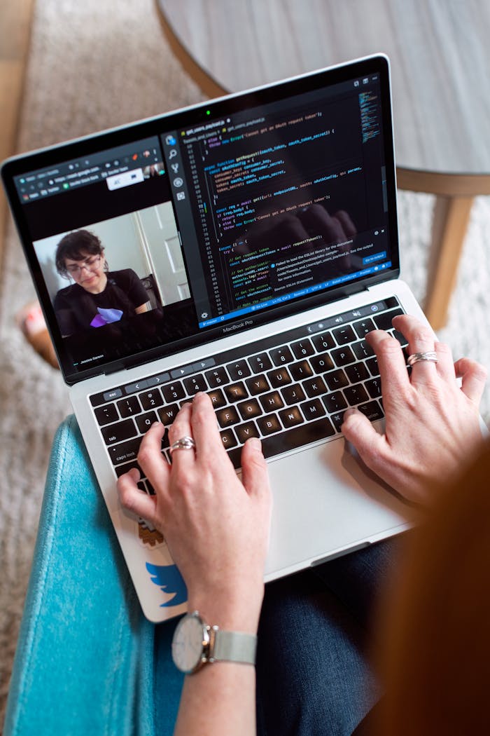 creative-02 Person coding on a laptop during a video conference, showcasing remote work.